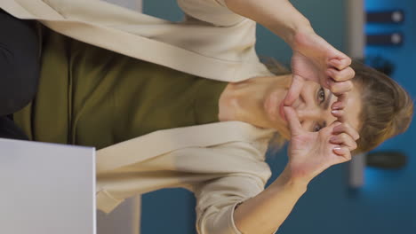 Vertical-video-of-Home-office-worker-woman-makes-heart-symbol-looking-at-camera.